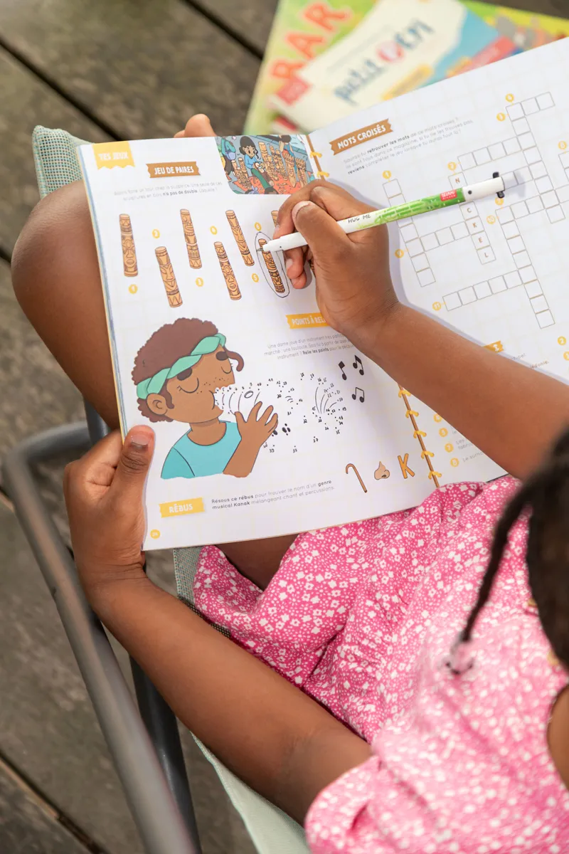 Enfant faisant les jeux du magazine Petit Péyi Nouvelle-Calédonie
